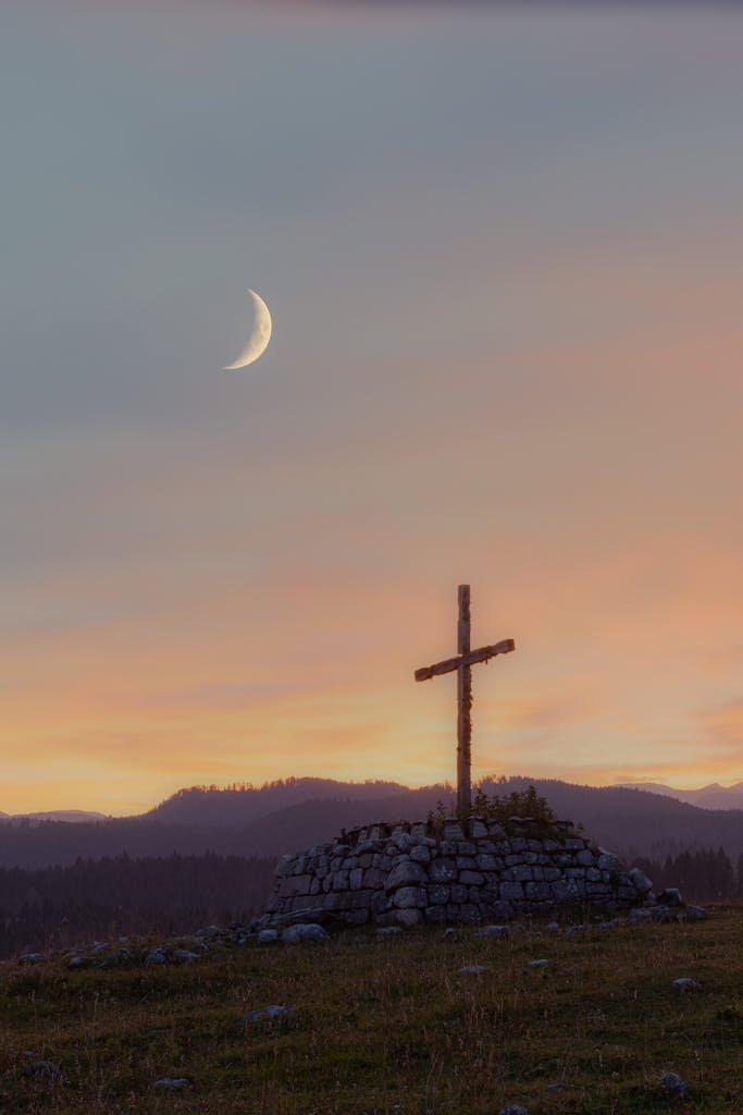 A beautiful cross under a crescent moon in the serene landscape of Enego, Veneto, Italy.
